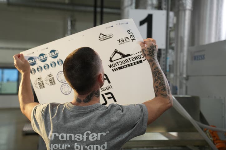 BIld på produktionspersonal som håller ett ark mot ljuset